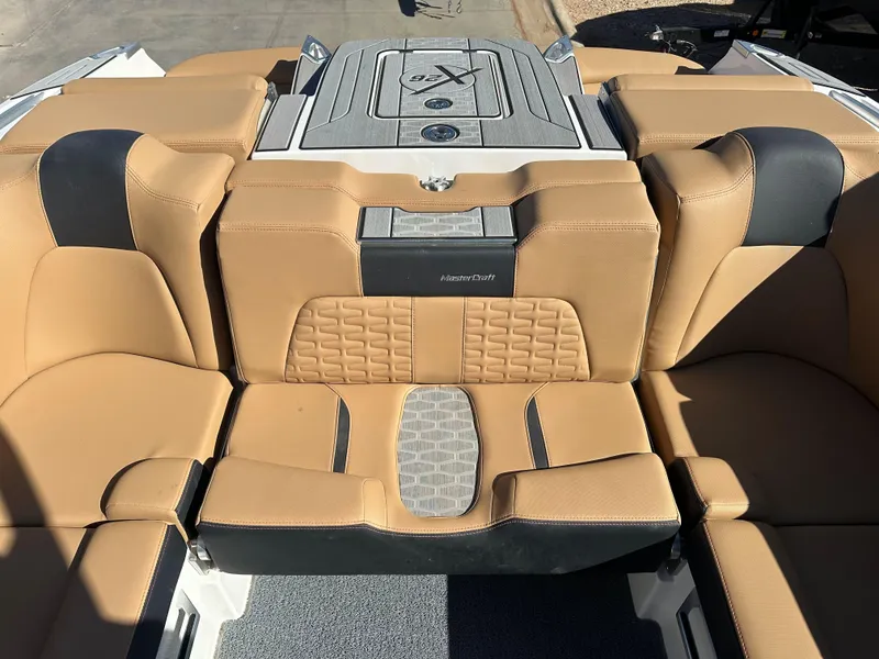 Slide: The Image of 2023 MasterCraft X26 boat interior with tan and black seating. - 12