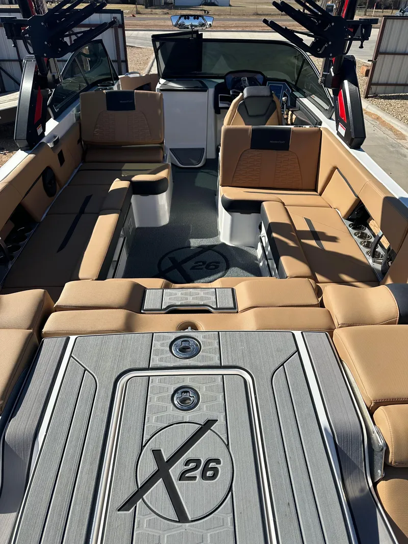 Slide: The Image of 2023 MasterCraft X26 boat interior with tan seating and sleek design. - 13