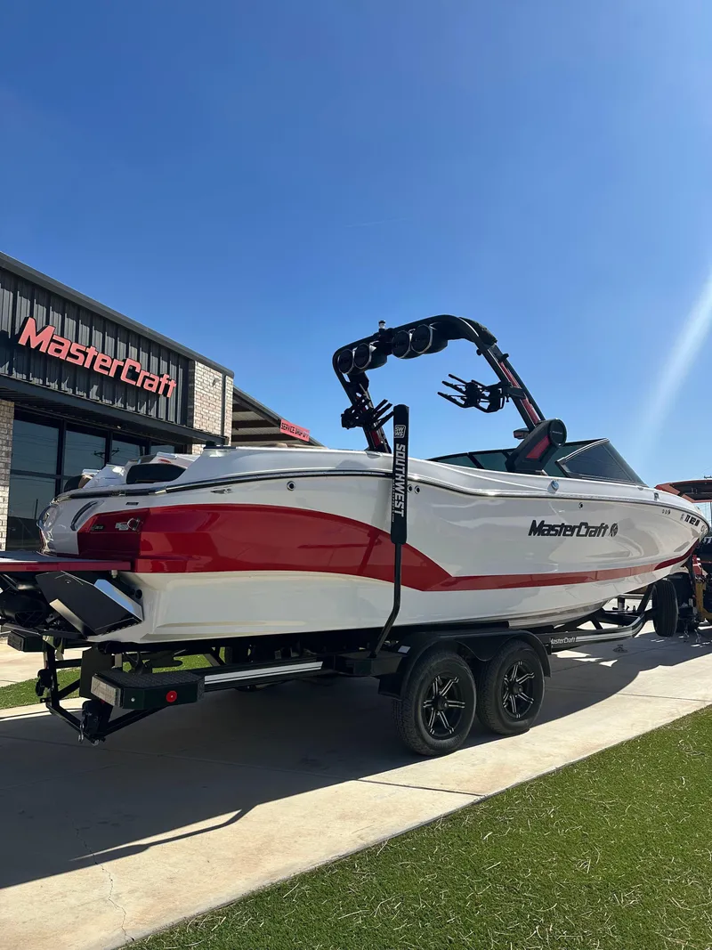 Slide: The Image of 2023 MasterCraft X26 boat displayed outdoors under clear blue sky. - 15