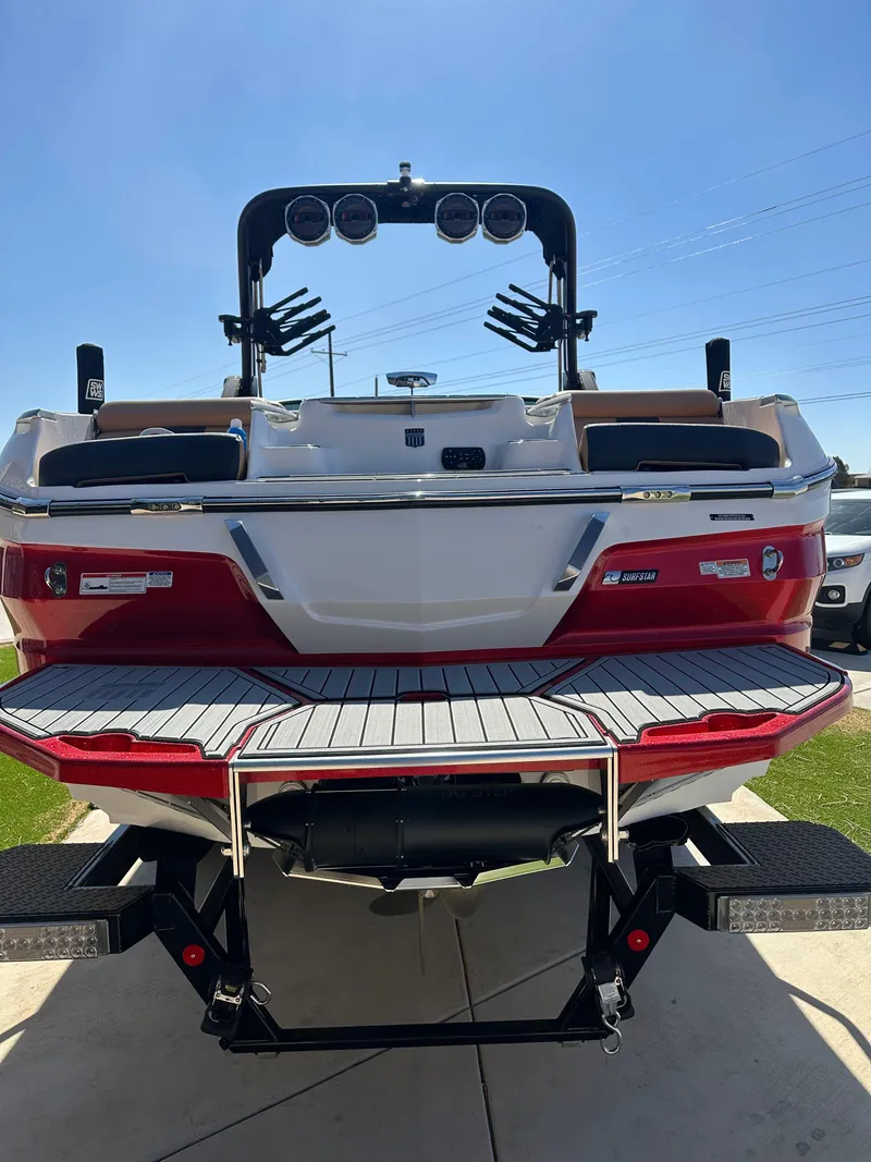 Slide: The Image of 2023 MasterCraft X26 boat, rear view, red and white design, on a sunny day. - 16