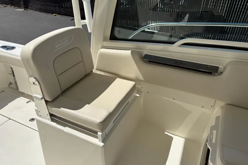 Slide: The Image of 2026 Boston Whaler 285 Conquest interior seat, featuring beige upholstery and sleek design. - 13