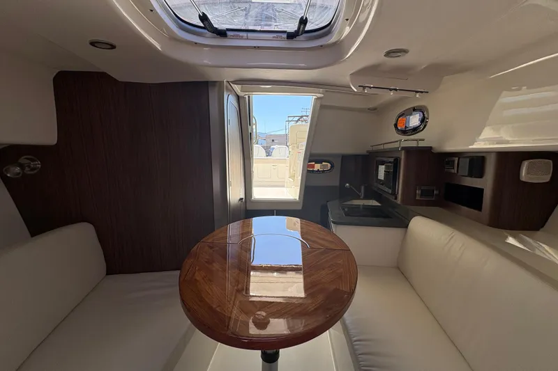 Slide: The Image of Interior of 2026 Boston Whaler 285 Conquest, featuring a cozy cabin with seating and kitchenette. - 15
