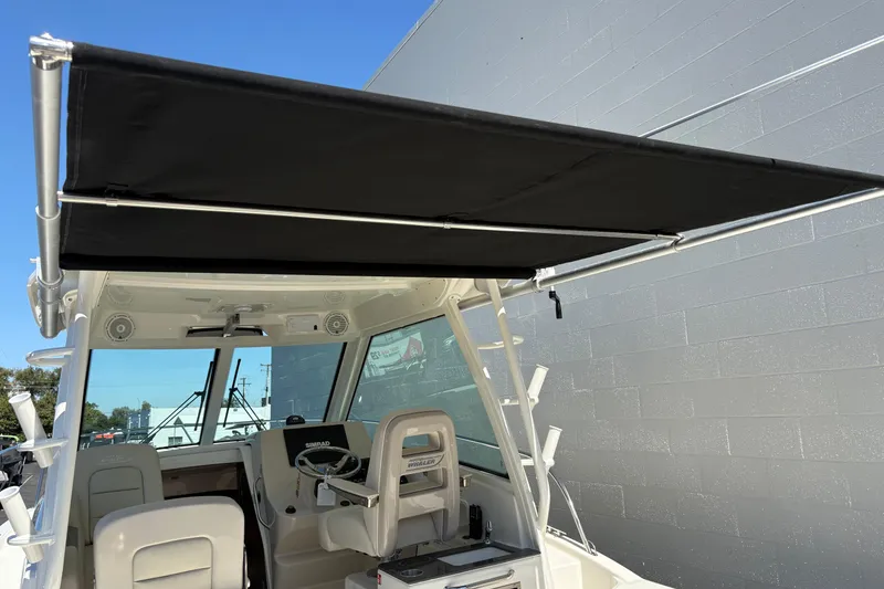 Slide: The Image of 2026 Boston Whaler 285 Conquest boat with black canopy and modern cockpit design. - 16