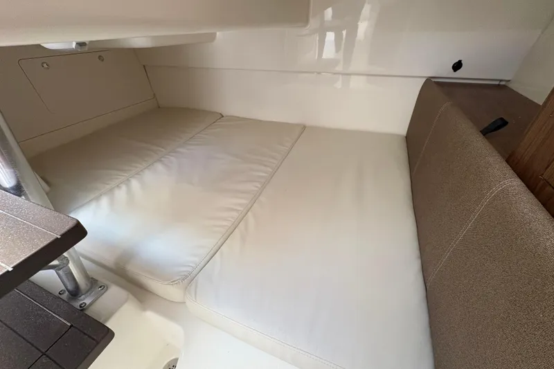 Slide: The Image of 2026 Boston Whaler 285 Conquest cabin interior with cushioned seating and compact design. - 18