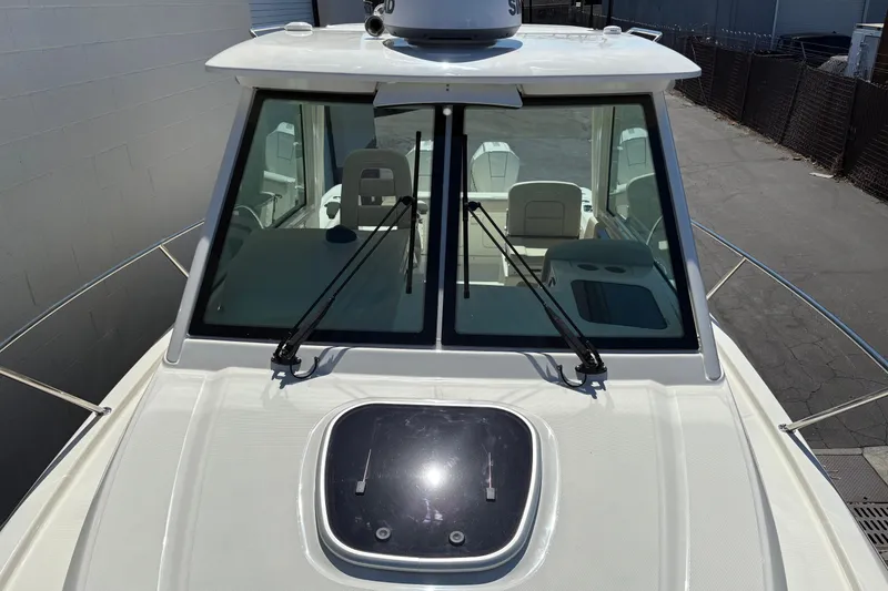 Slide: The Image of 2026 Boston Whaler 285 Conquest boat, front view with windshield and deck hatch. - 21