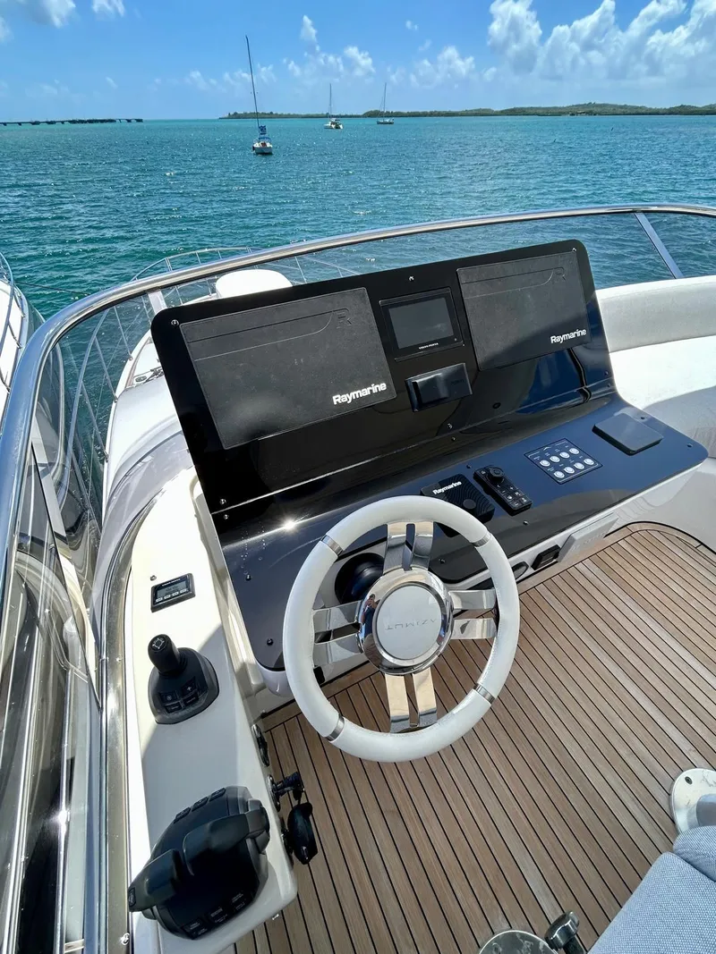 Slide: The Image of 2023 Azimut Fly 60 yacht helm with modern controls, on a serene ocean backdrop. - 12
