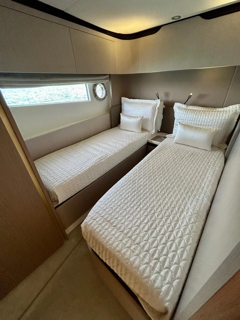 Slide: The Image of 2023 Azimut Fly 60 yacht cabin with twin beds, modern design, and elegant bedding. - 16