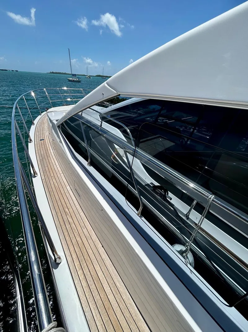 Slide: The Image of 2023 Azimut Fly 60 yacht with sleek design and wooden deck, cruising on a sunny day. - 17
