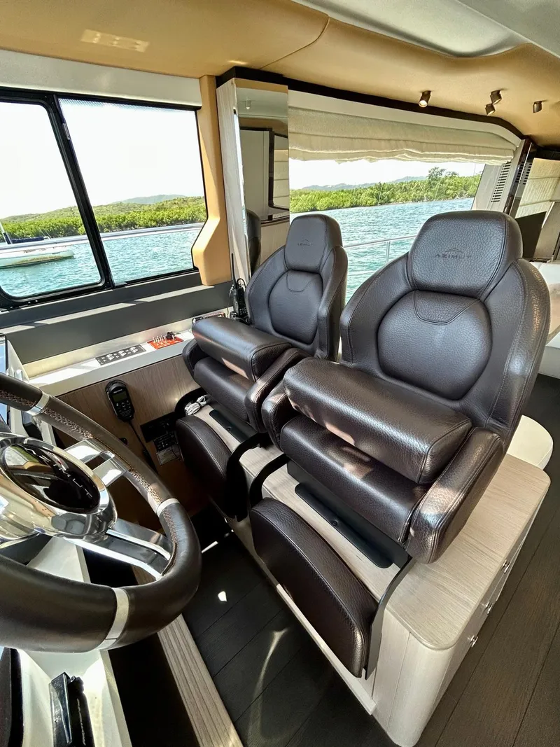 Slide: The Image of 2023 Azimut Fly 60 yacht interior with luxurious leather seating and modern steering wheel. - 24