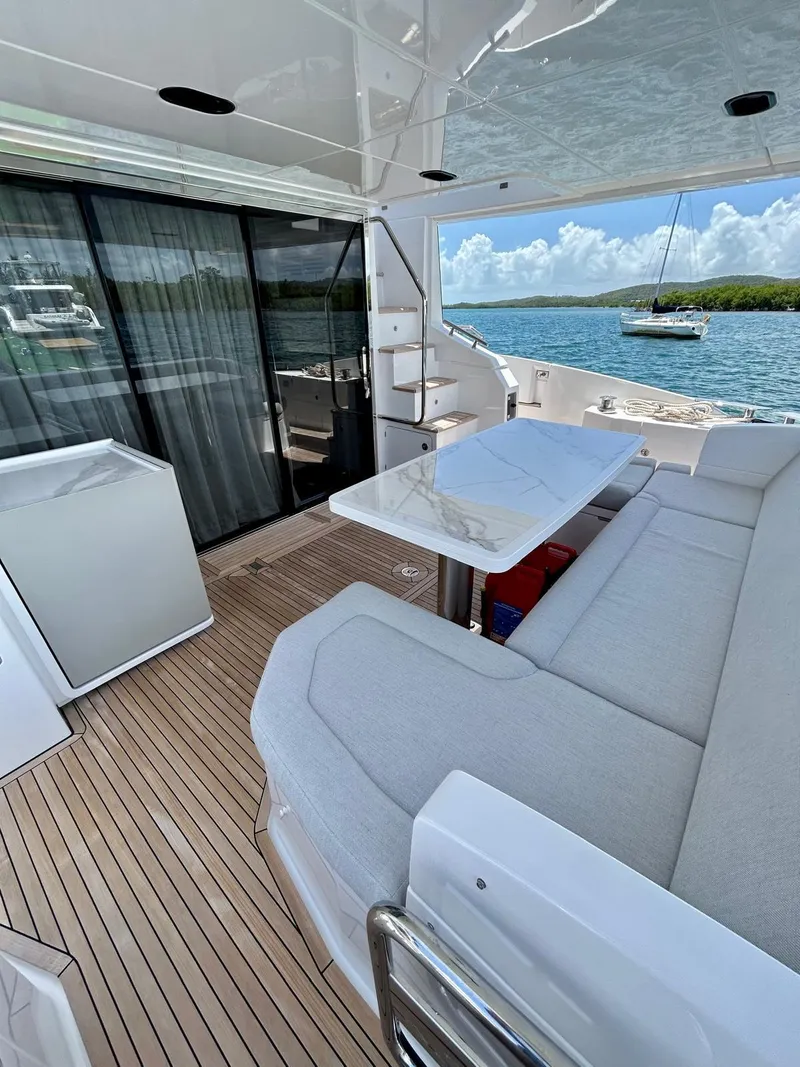 Slide: The Image of 2023 Azimut Fly 60 yacht deck with seating, table, and ocean view. - 29