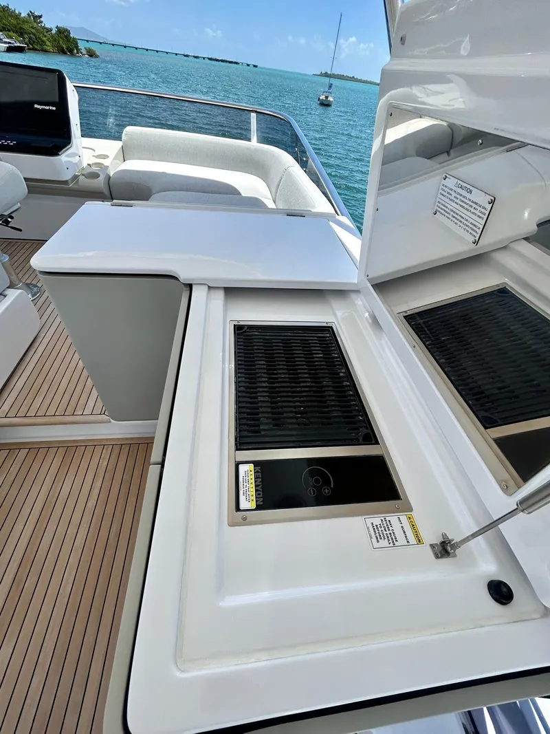 Slide: The Image of 2023 Azimut Fly 60 yacht deck with grill, overlooking serene blue waters. - 30