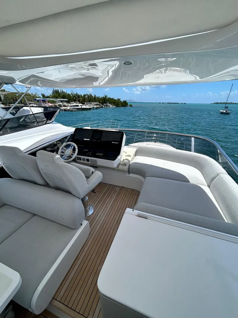Slide: The Image of 2023 Azimut Fly 60 yacht with luxurious deck, overlooking serene ocean and distant shoreline. - 34