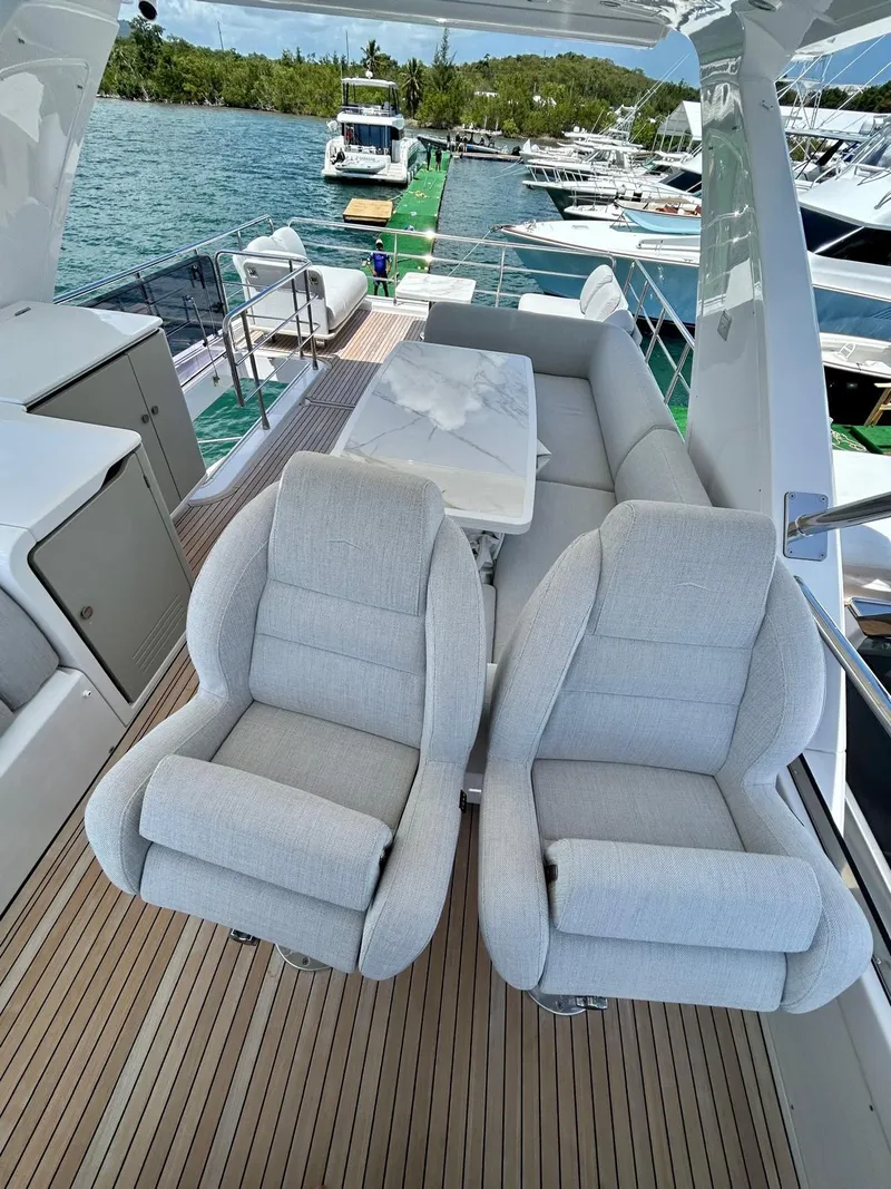 Slide: The Image of 2023 Azimut Fly 60 yacht deck with plush seating and scenic marina view. - 40