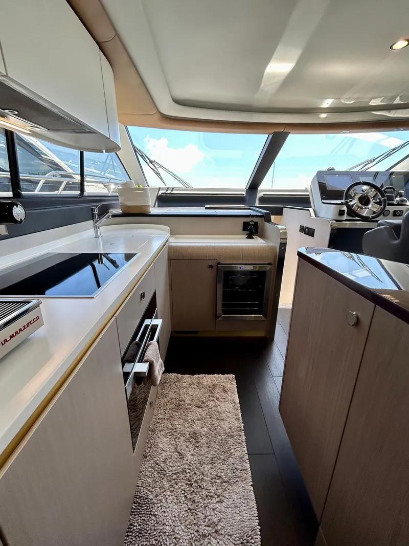 Slide: The Image of Interior of 2023 Azimut Fly 60 yacht, featuring modern kitchen and helm station. - 45