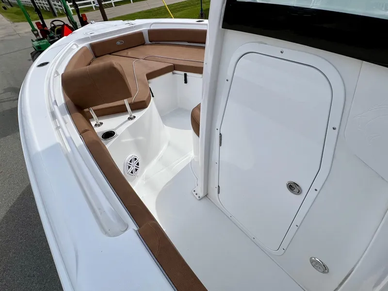 Slide: The Image of 2025 Sea Hunt Ultra 235SE boat interior with brown seating and white deck. - 12