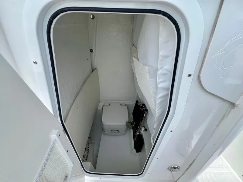 Slide: The Image of 2025 Sea Hunt Ultra 235SE boat interior with compact marine toilet. - 13