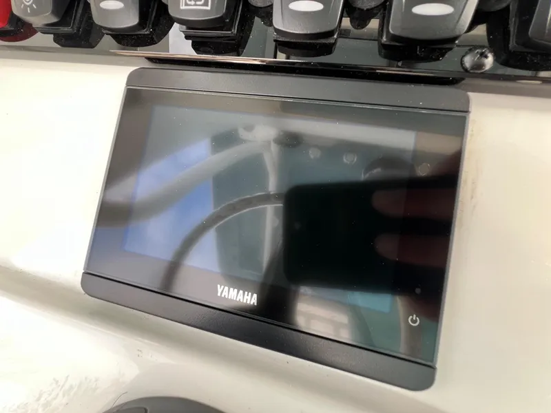Slide: The Image of Yamaha display on 2025 Sea Hunt Ultra 235SE boat dashboard with control buttons. - 18
