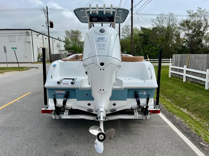Slide: The Image of 2025 Sea Hunt Ultra 235SE boat, rear view on a street, showcasing outboard motor. - 3