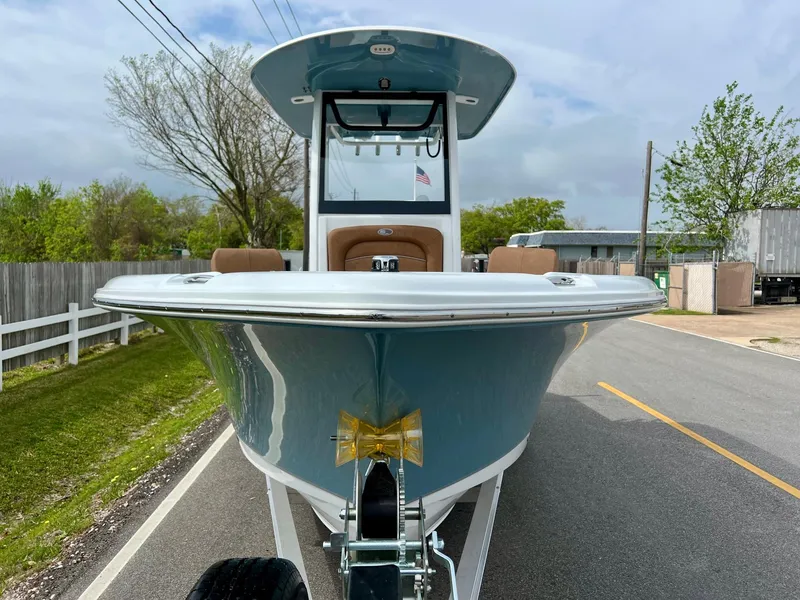 Slide: The Image of 2025 Sea Hunt Ultra 235SE boat on trailer, front view, parked on a road. - 6