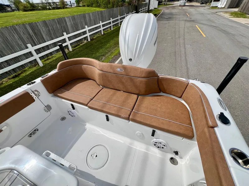 Slide: The Image of 2025 Sea Hunt Ultra 235SE boat with brown seating, white deck, and outdoor setting. - 7