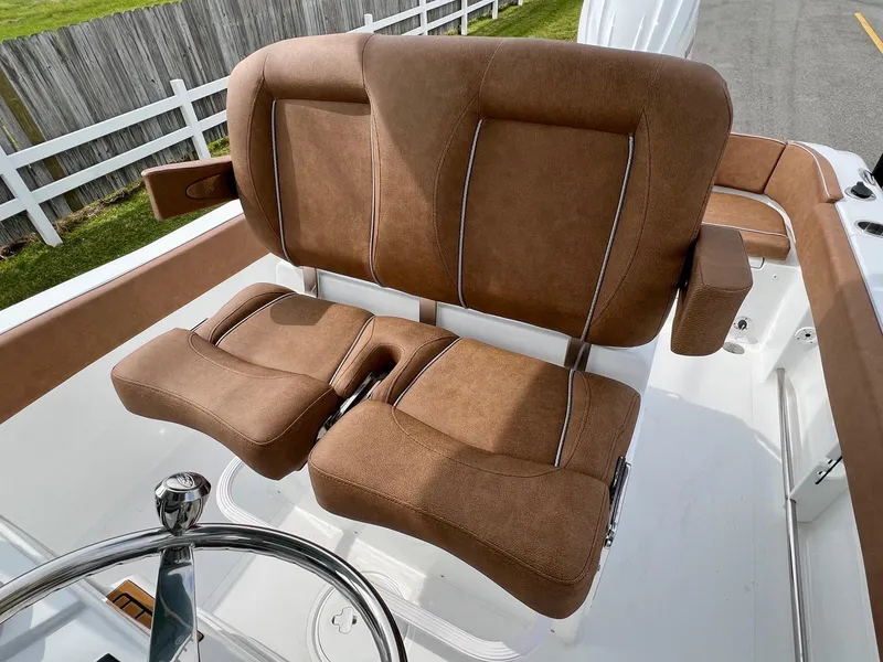Slide: The Image of 2025 Sea Hunt Ultra 235SE boat seats with brown upholstery and steering wheel. - 9