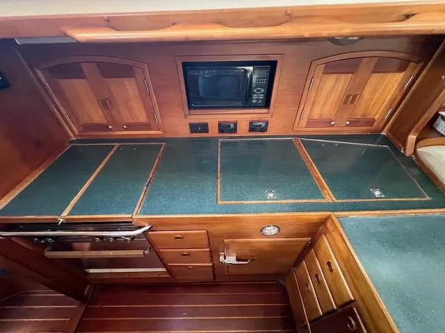 Slide: The Image of 1996 Sabre 402 yacht kitchen with wood cabinetry and green countertops. - 10