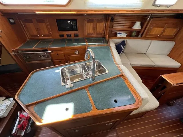 Slide: The Image of Interior of a 1996 Sabre 402 yacht featuring a kitchen and seating area. - 15