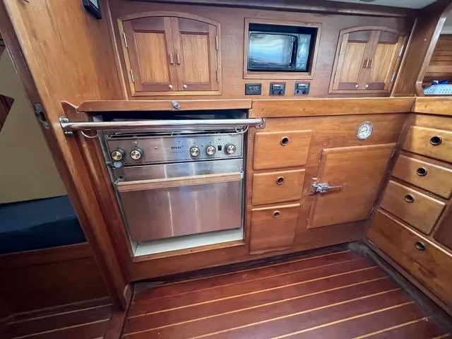Slide: The Image of 1996 Sabre 402 yacht interior with wooden cabinetry and built-in oven. - 16