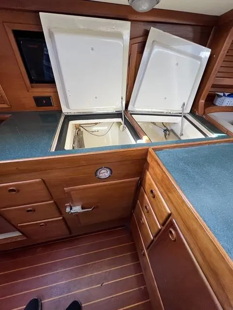 Slide: The Image of 1996 Sabre 402 yacht interior with open storage compartments and wooden cabinetry. - 17