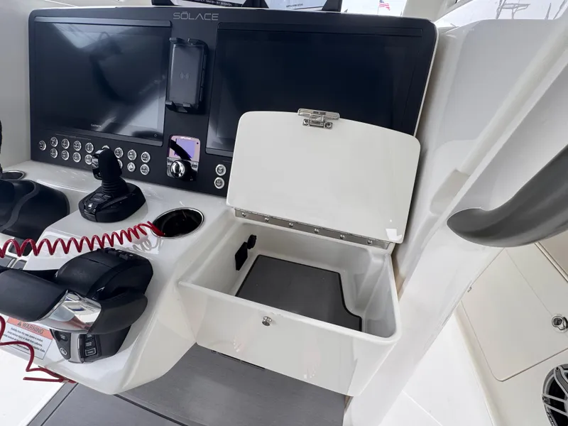 Slide: The Image of Control panel of 2025 Solace 30 CS boat with open storage compartment. - 19