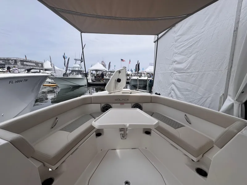 Slide: The Image of 2025 Solace 30 CS boat interior at a marina, showcasing seating and table. - 28