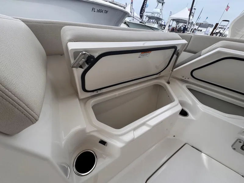 Slide: The Image of 2025 Solace 30 CS boat storage compartment with open hatch and cup holder. - 34