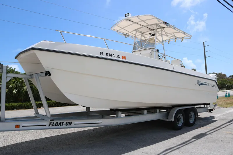 Slide: The Image of 1996 Sea Cat SL5 boat on trailer under clear blue sky. - 0
