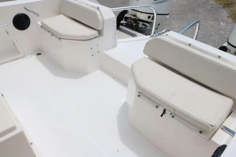 Slide: The Image of 1996 Sea Cat SL5 boat interior with white cushioned seating and storage compartments. - 11