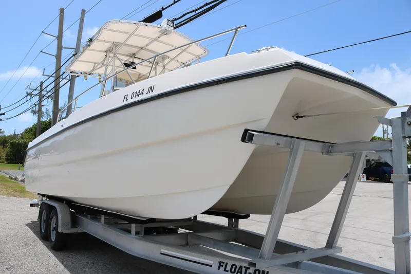 Slide: The Image of 1996 Sea Cat SL5 boat on trailer, white hull, outdoor setting. - 2