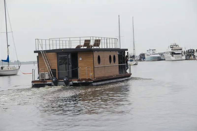 Slide: The Image of Modern Waterlodge Apart XXL houseboat cruising in marina, 2025 model, with rooftop seating. - 1