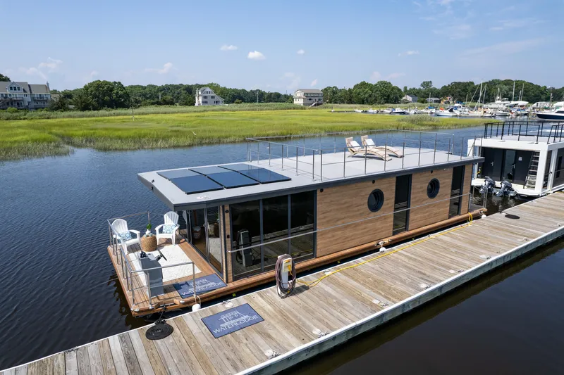 Slide: The Image of Modern Waterlodge Apart XXL houseboat docked, featuring solar panels and rooftop seating, 2025 model. - 11
