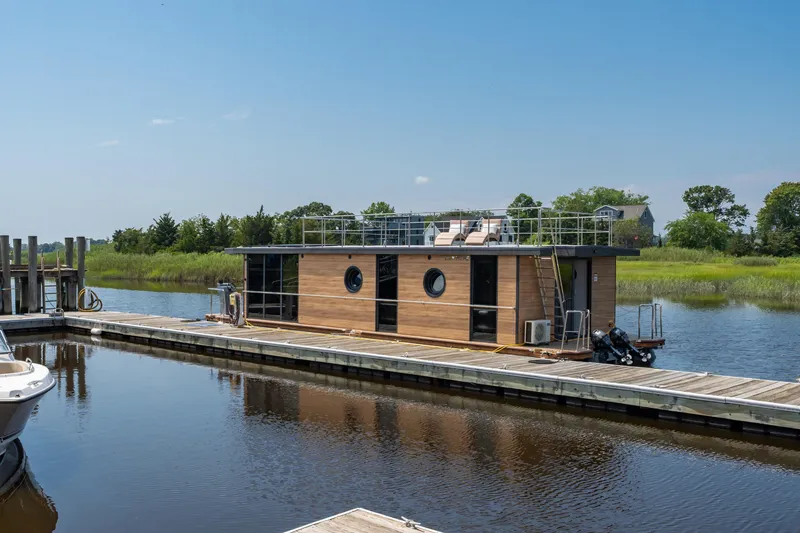 Slide: The Image of Modern Waterlodge Apart XXL houseboat docked on a serene river, 2025 model. - 12