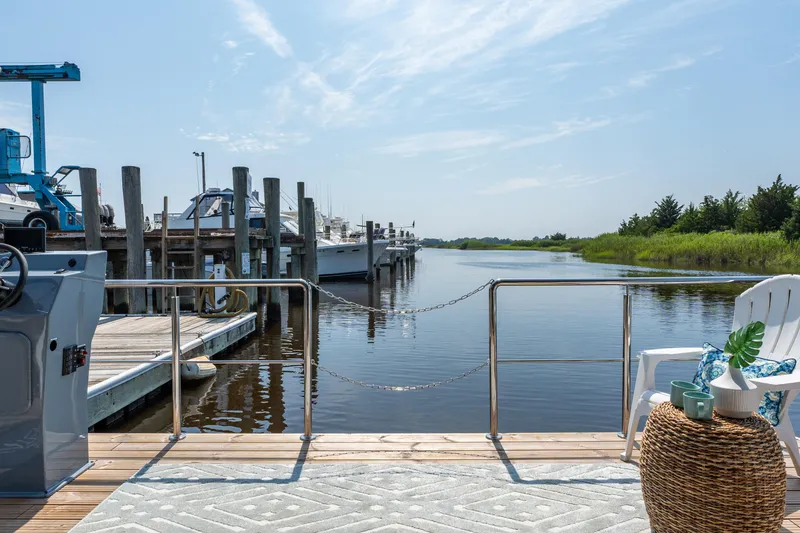 Slide: The Image of Waterlodge Apart XXL 2025 houseboat docked by serene marina with clear skies. - 13