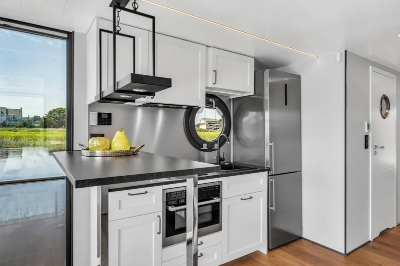 Slide: The Image of Modern kitchen in 2025 Waterlodge Apart XXL houseboat with sleek appliances and circular window. - 15