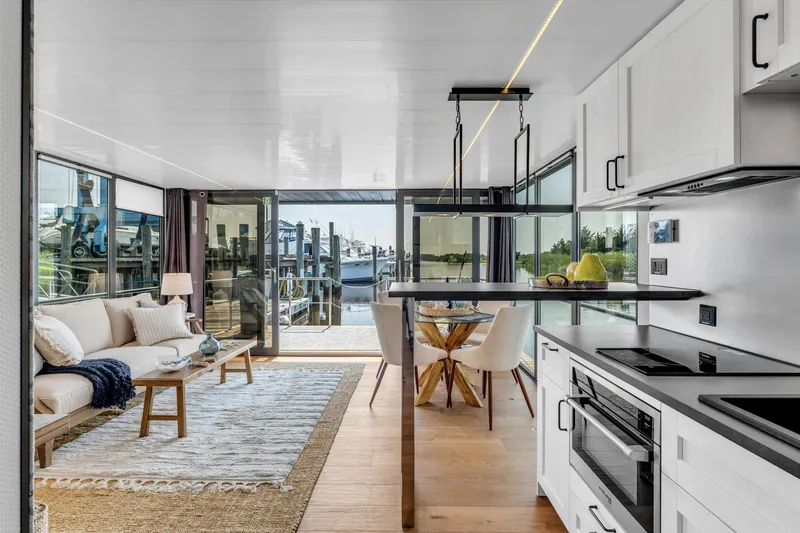 Slide: The Image of Modern Waterlodge Apart XXL 2025 interior with kitchen, dining area, and waterfront view. - 16