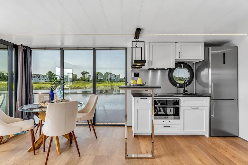 Slide: The Image of Modern Waterlodge Apart XXL 2025 interior with kitchen, dining area, and large windows overlooking water. - 18