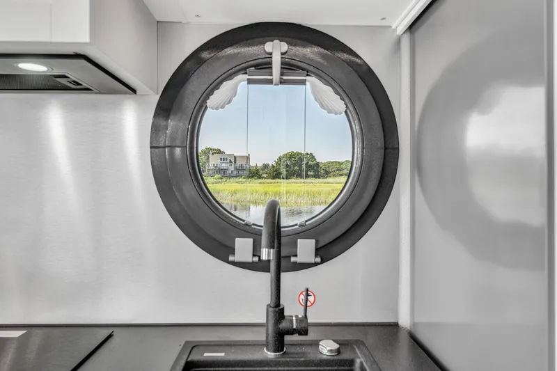 Slide: The Image of Modern kitchen interior with round window view in Waterlodge Apart XXL 2025 houseboat. - 20