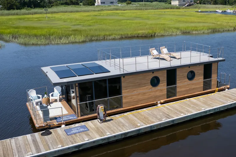 Slide: The Image of Modern Waterlodge Apart XXL houseboat with solar panels docked on a serene river, 2025 model. - 3