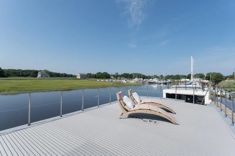 Slide: The Image of Modern Waterlodge Apart XXL 2025 on serene river with sun loungers and scenic view. - 34