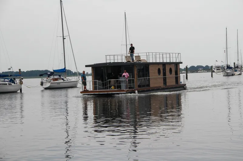 Slide: The Image of Houseboat Waterlodge Apart XXL 2025 on calm water, surrounded by sailboats. - 35