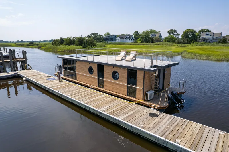 Slide: The Image of Modern Waterlodge Apart XXL houseboat docked on a serene river, featuring rooftop seating. - 39