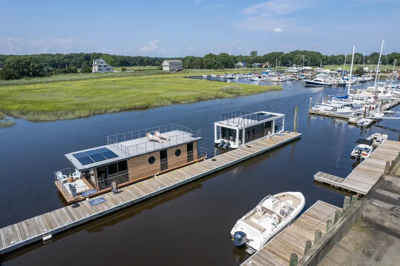 Slide: The Image of Houseboats docked in a marina, featuring Waterlodge Apart XXL 2025 models with solar panels. - 41