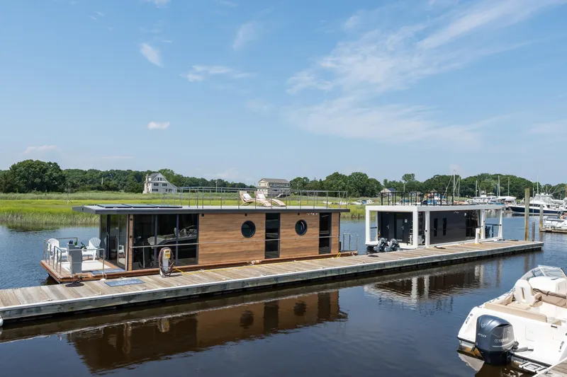 Slide: The Image of Modern Waterlodge Apart XXL houseboats docked on a serene river, 2025 model. - 44