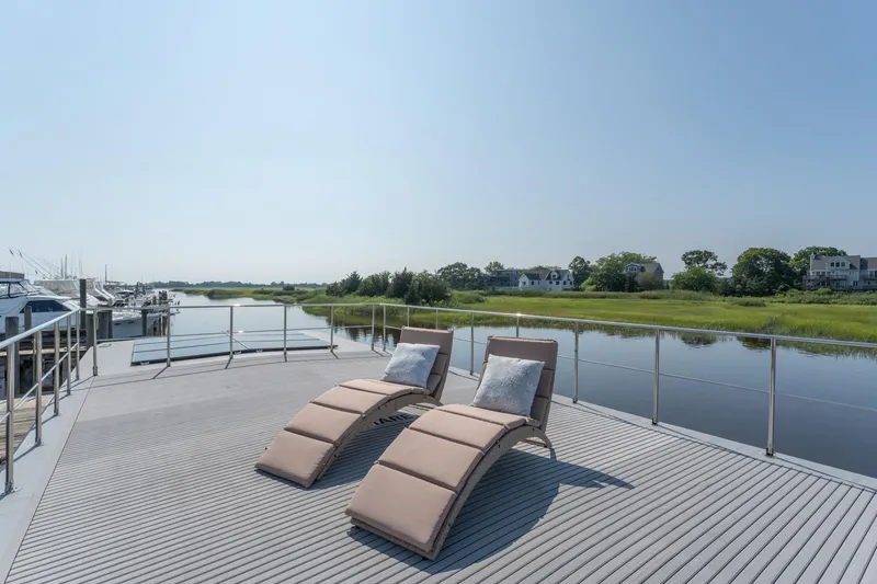 Slide: The Image of Deck of Waterlodge Apart XXL 2025 with loungers overlooking serene water and greenery. - 6